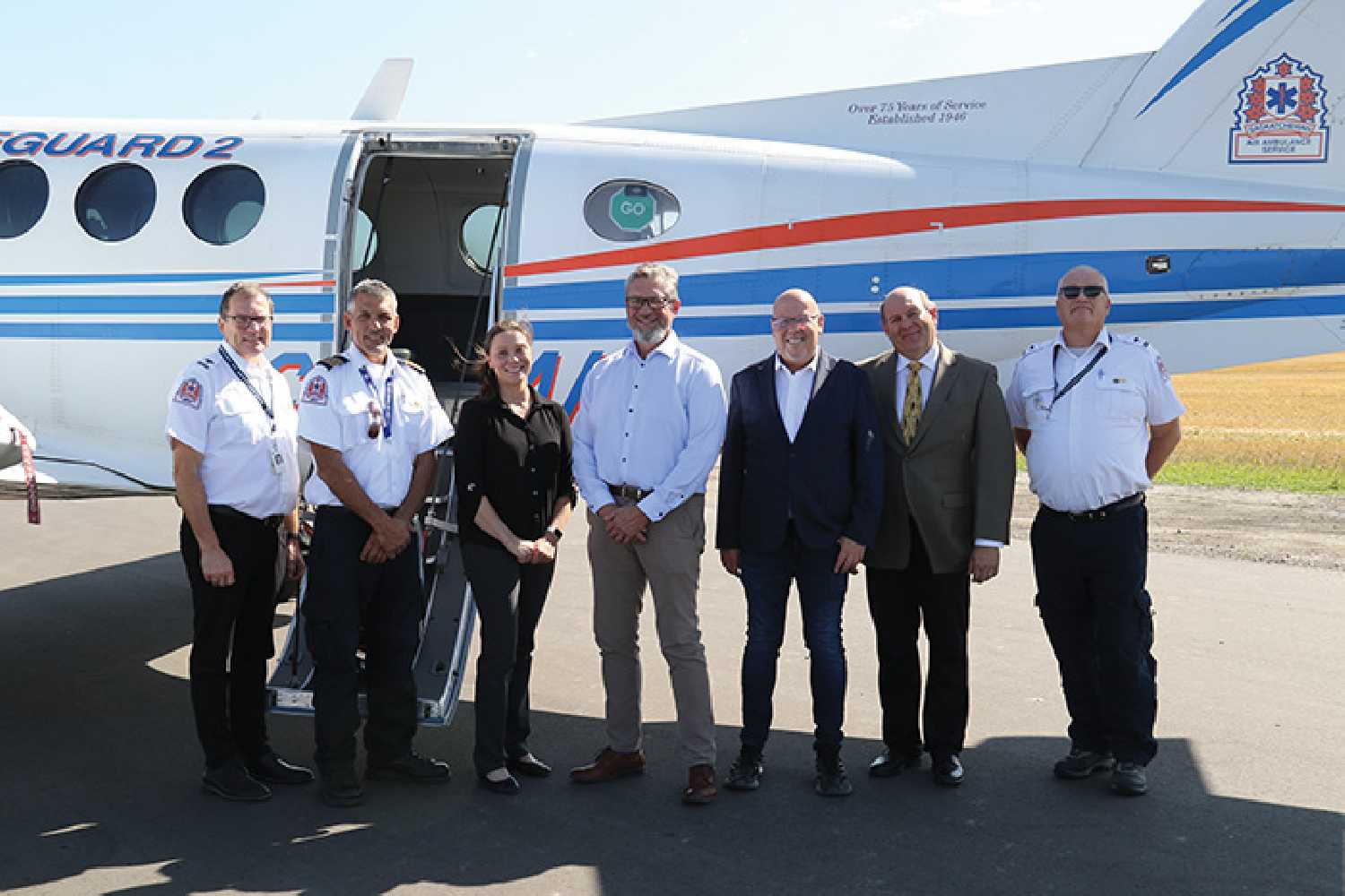 Members of the Saskatchewan Air Ambulance crew, Dr. Schalk van der Merwe with the airport expansion committee, and Kevin Weedmark with the Moosomin Chamber of Commerce standing in front of the Saskatchewan Air Ambulance jet. Currently jets can only land and take off during the day until lights are put up at the new runway.